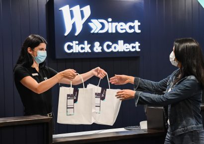 Two women where masks, one woman is receiving her purchases